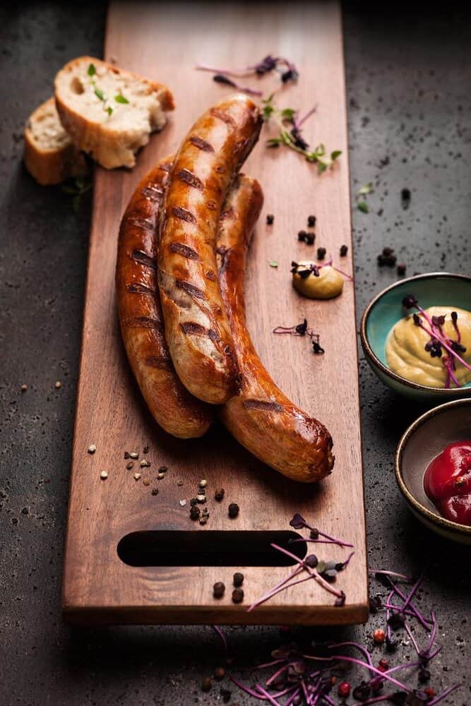 Gegrillte Würste mit Senf und Ketchup auf Brett